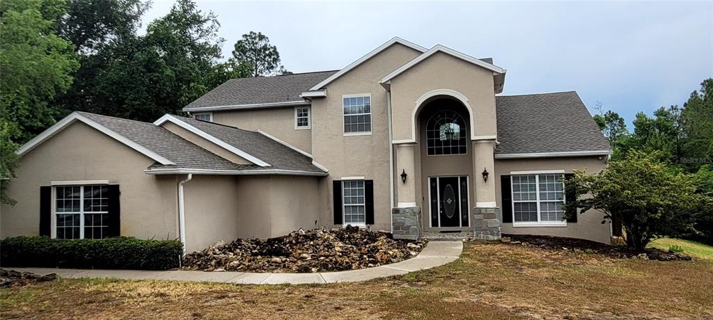 a front view of a house with garden