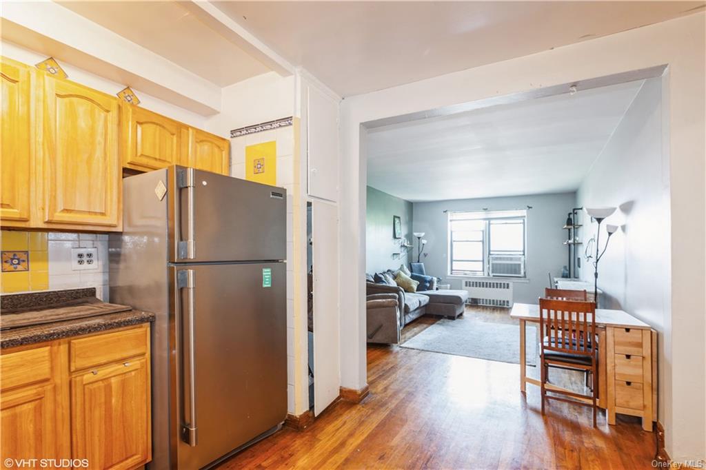 a kitchen with stainless steel appliances a refrigerator and wooden floor