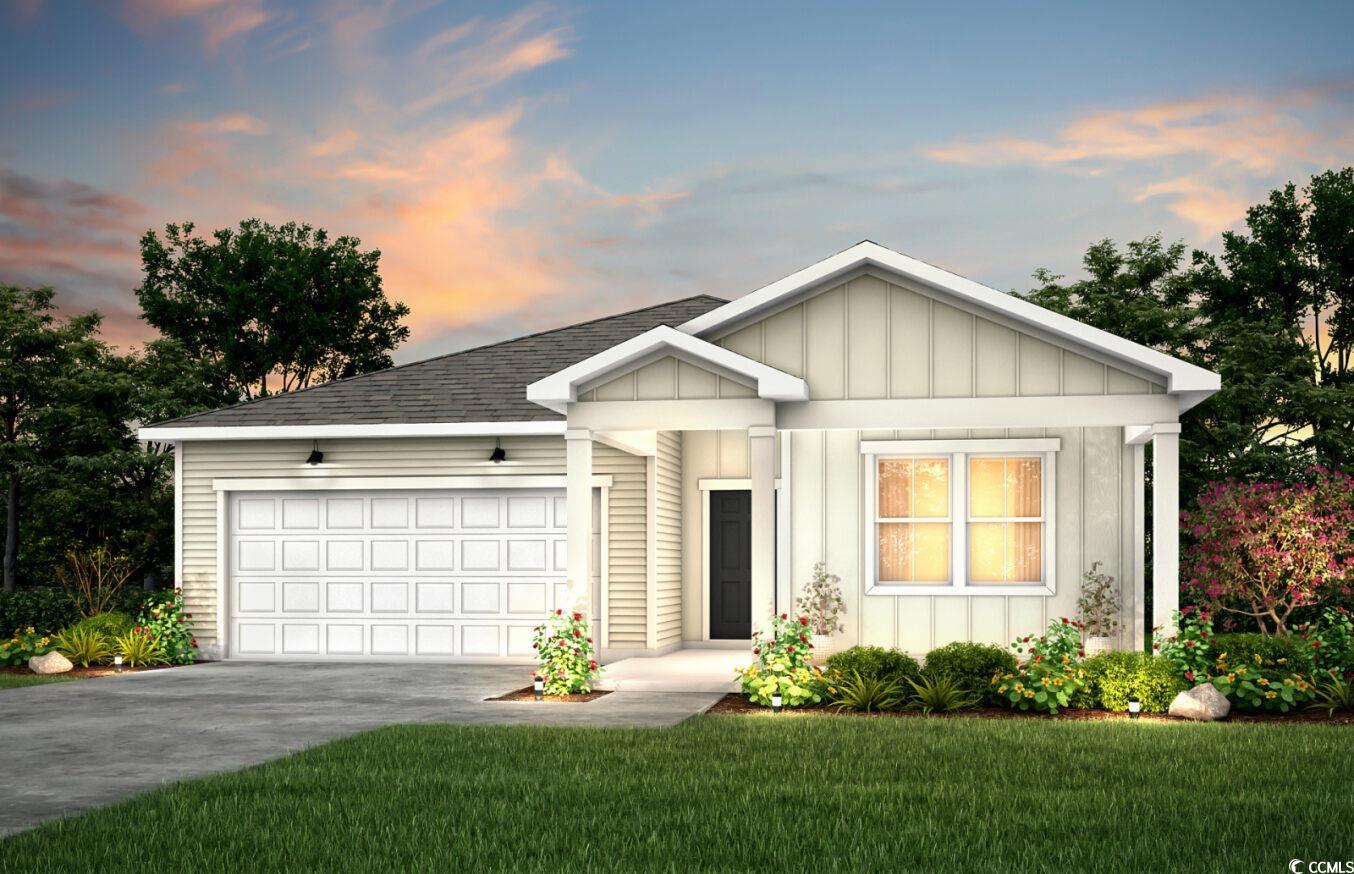 View of front facade featuring a yard and a garage