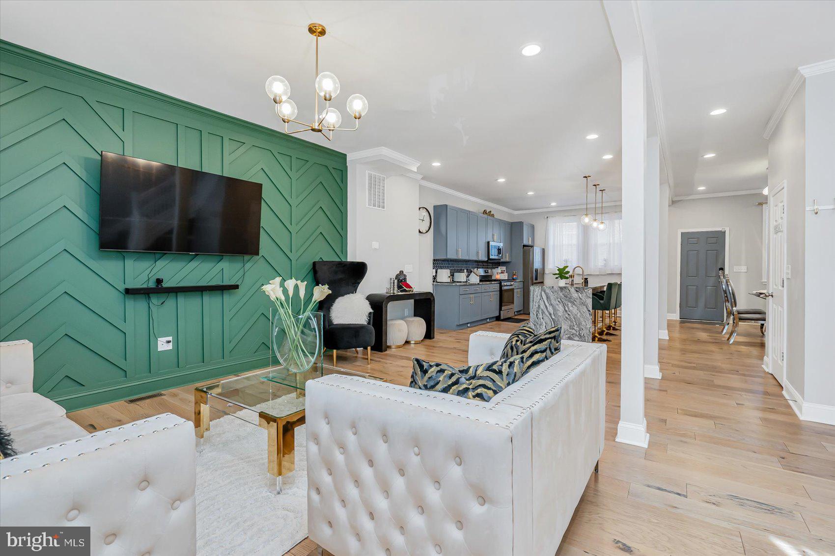 a living room with furniture a flat screen tv and kitchen view