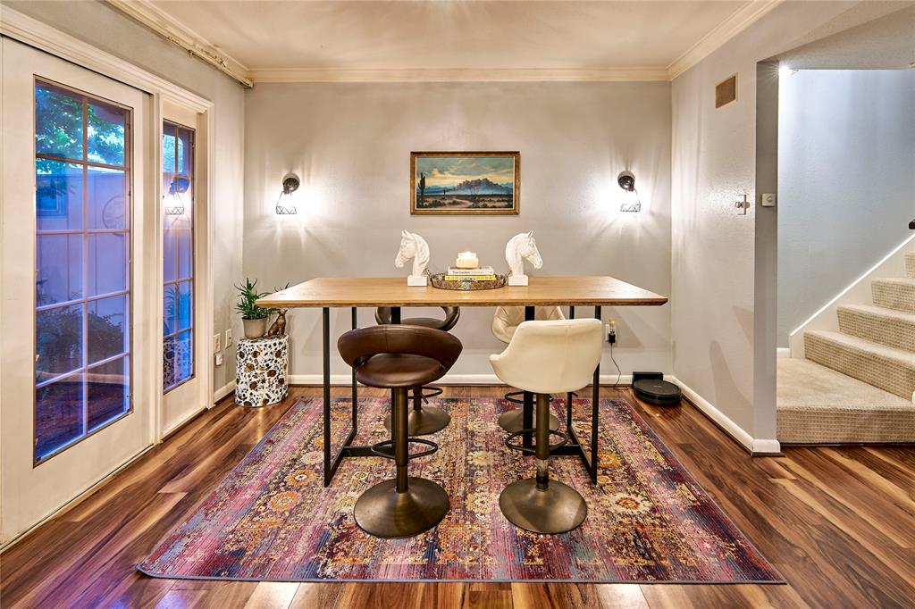 a view of a dining room with furniture a rug and wooden floor