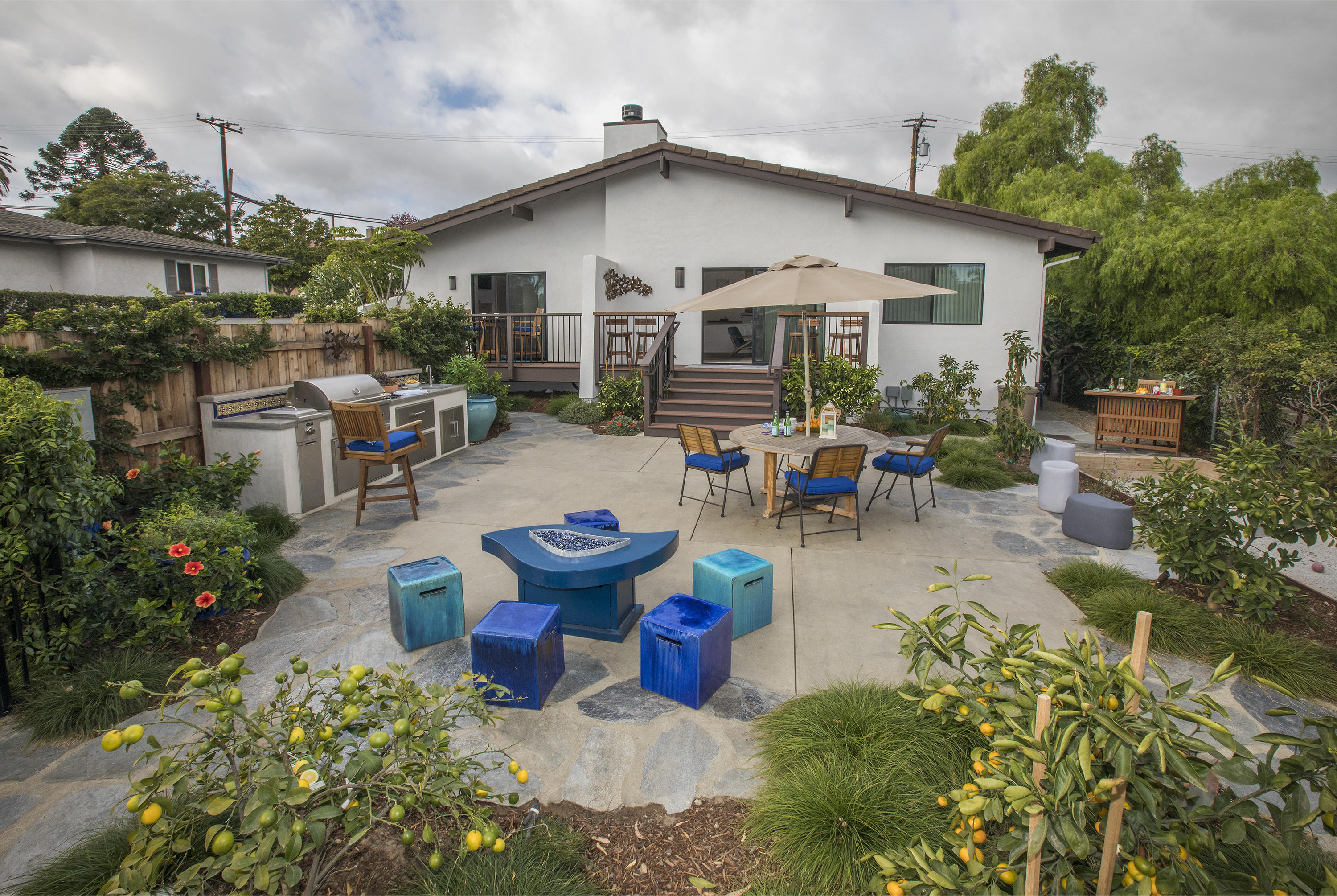 a view of a patio with table and chairs potted plants and a large tree