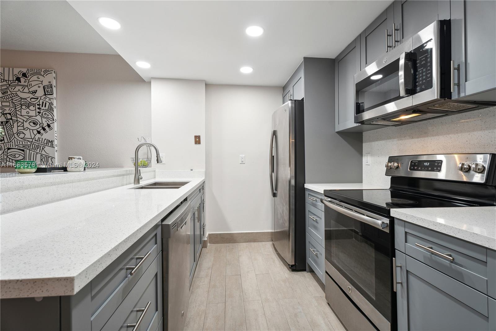 a kitchen with stainless steel appliances granite countertop a sink stove and refrigerator