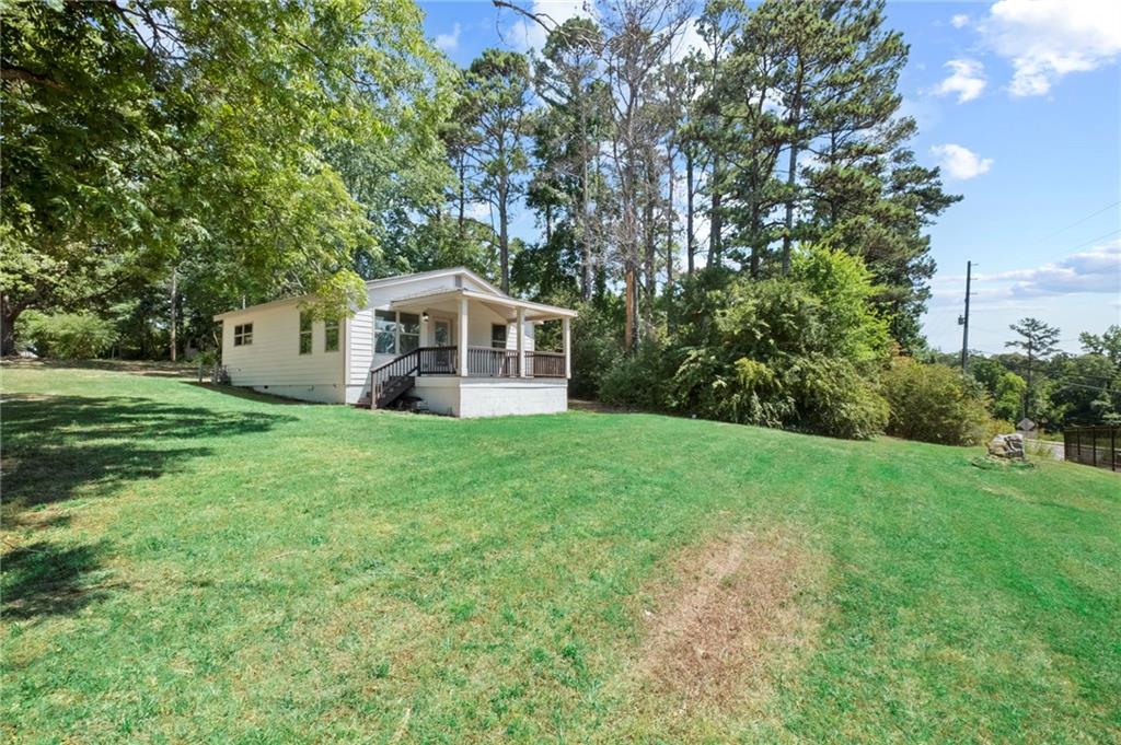 a view of a house with a big yard and large trees