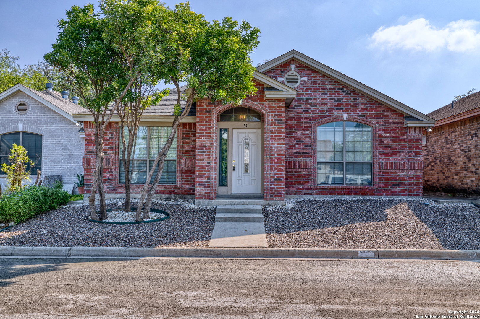 front view of a house with a tree