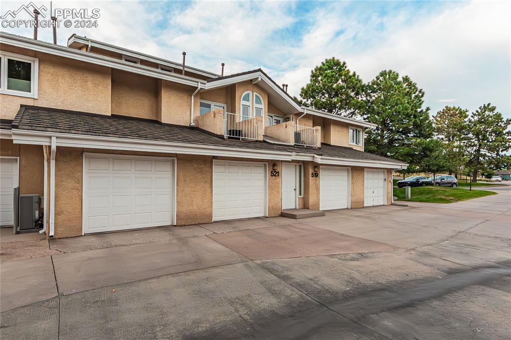 View of front of property with a garage and a balcony