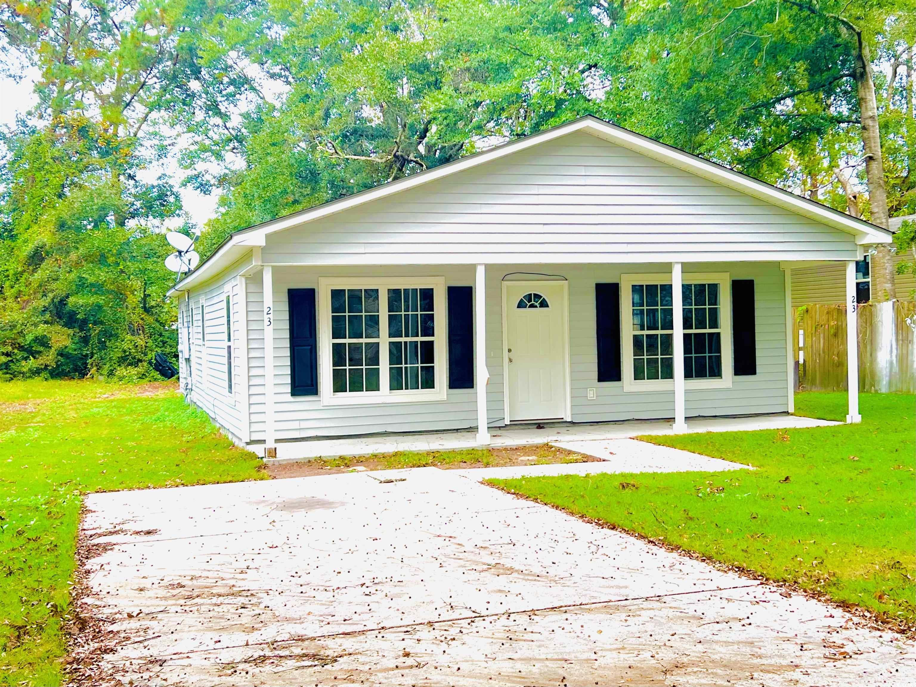 Bungalow-style home with a front lawn and covered