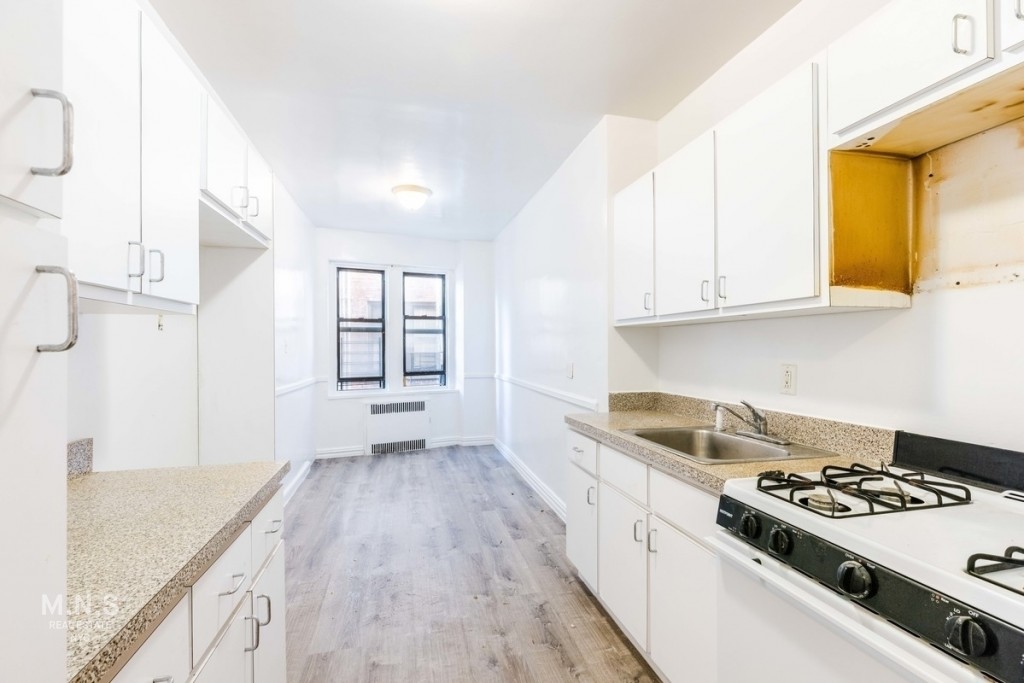 a kitchen with a sink stove and cabinets