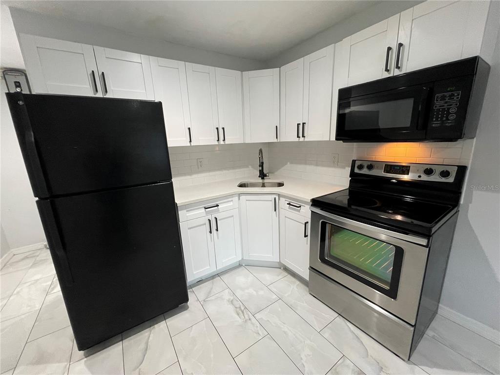 a kitchen with a sink a stove and refrigerator