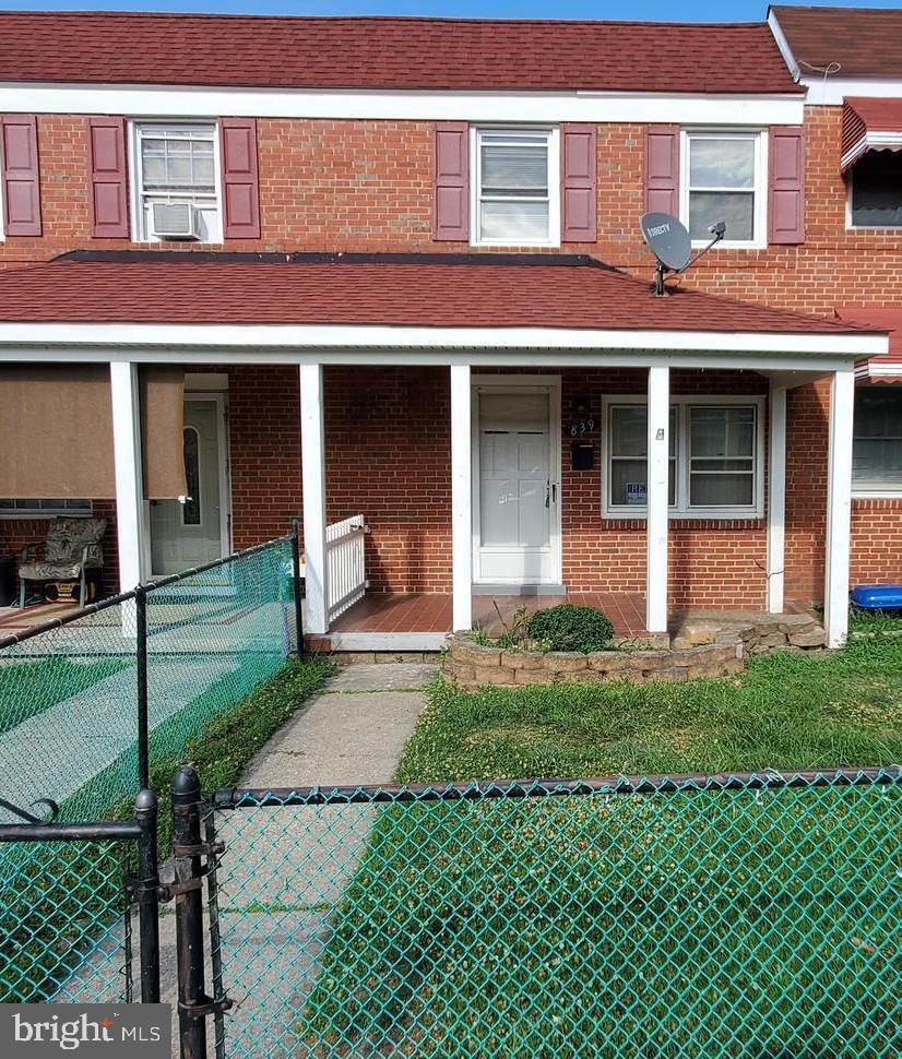 front view of a brick house with a yard