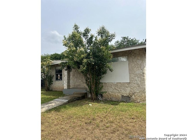 a view of a house with a tree in front of it