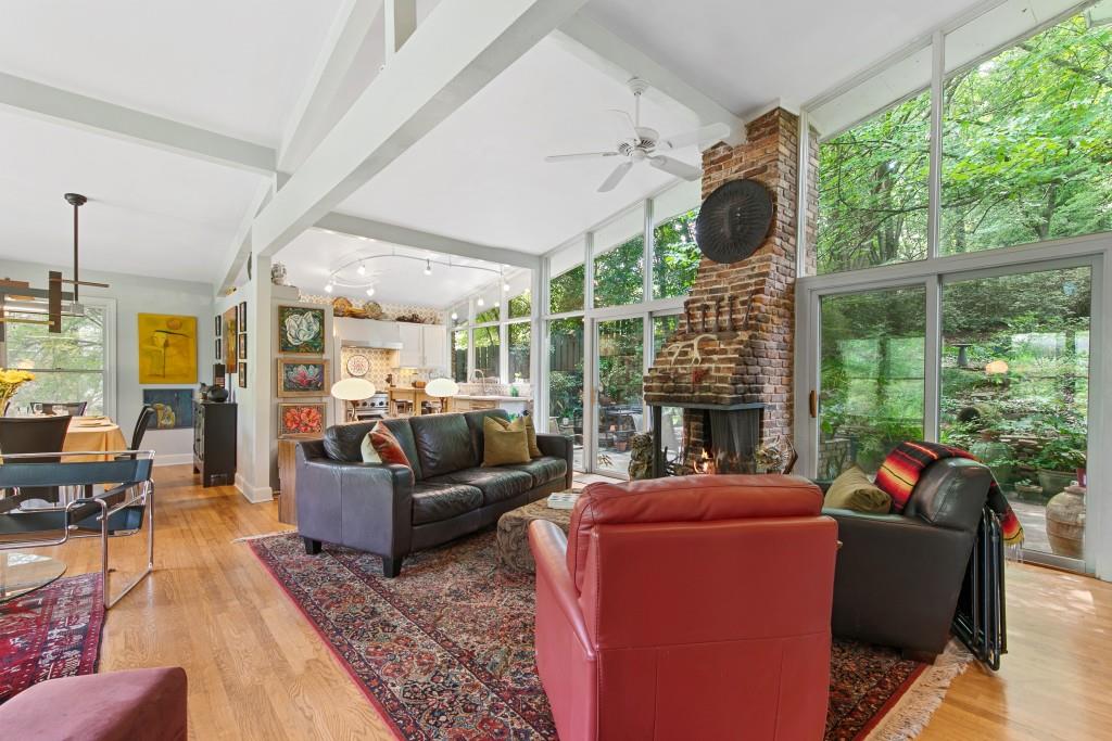 a living room with furniture a fireplace and a floor to ceiling window