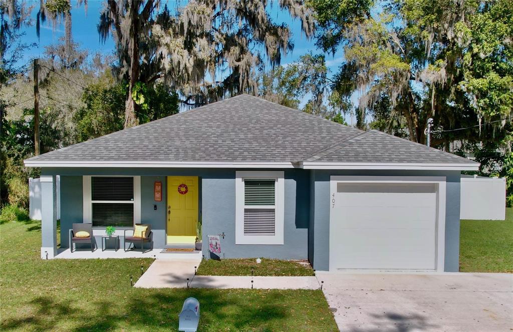 a view of a house with backyard porch and tree