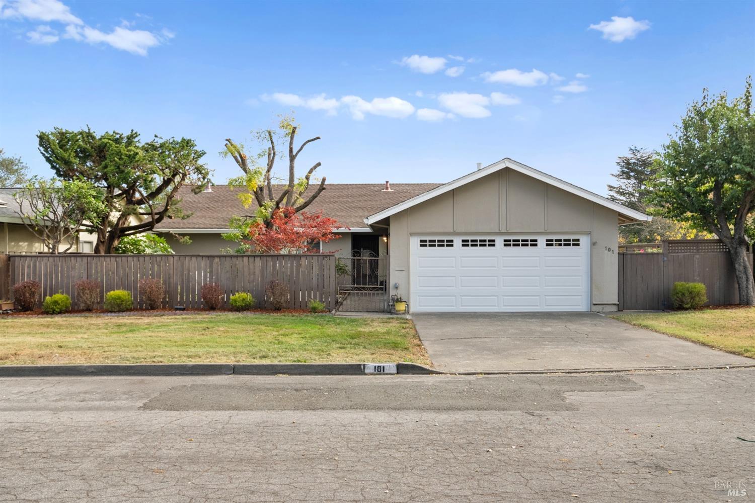 a view of a house with a yard and large trees