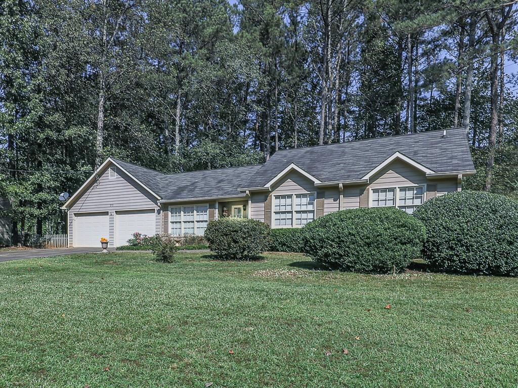 a front view of a house with a yard and trees