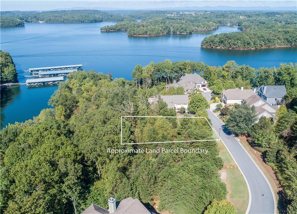 an aerial view of residential houses with outdoor space and lake view