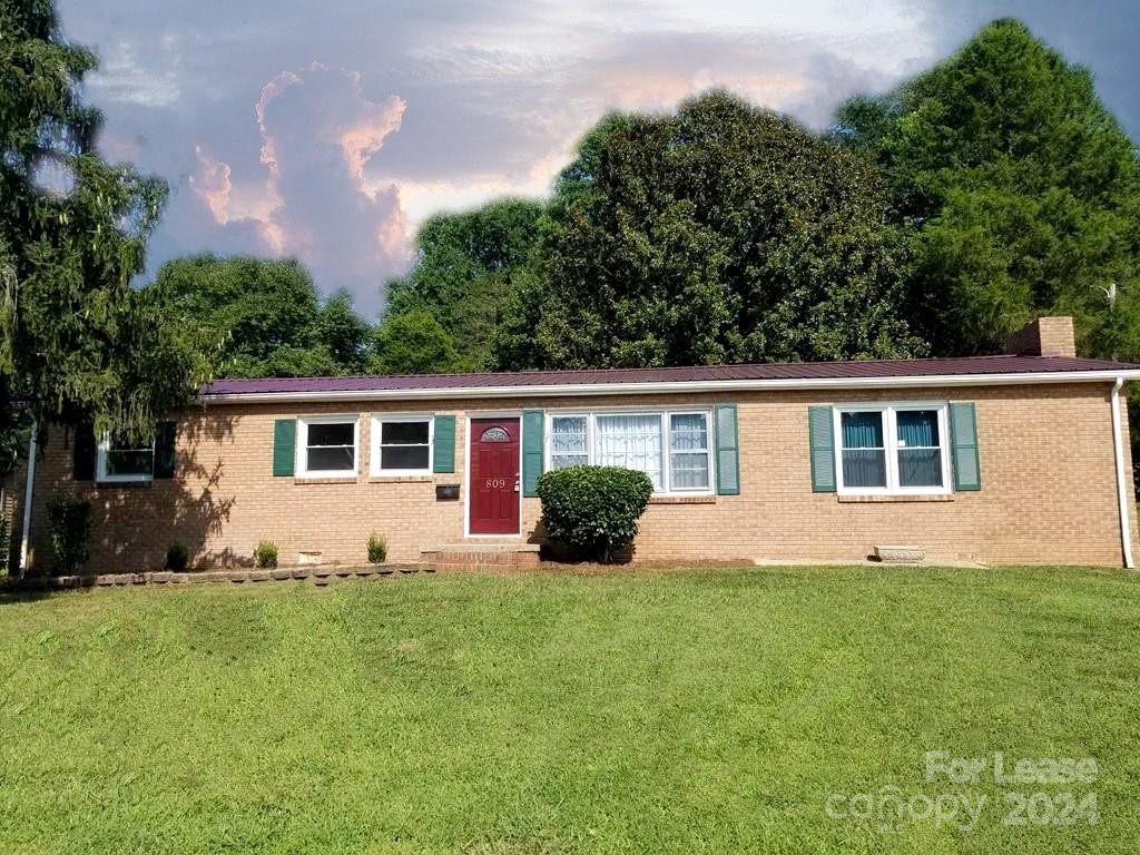 a front view of a house with a yard and trees