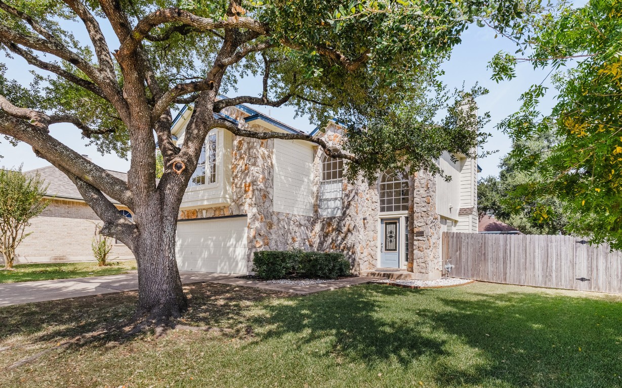 a view of a house with a tree in the yard