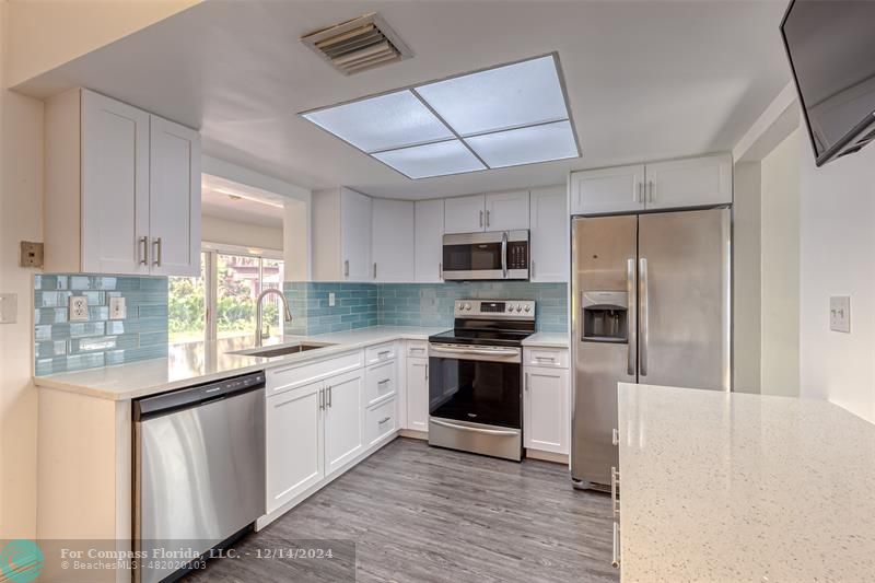 a kitchen with stainless steel appliances a refrigerator sink and microwave