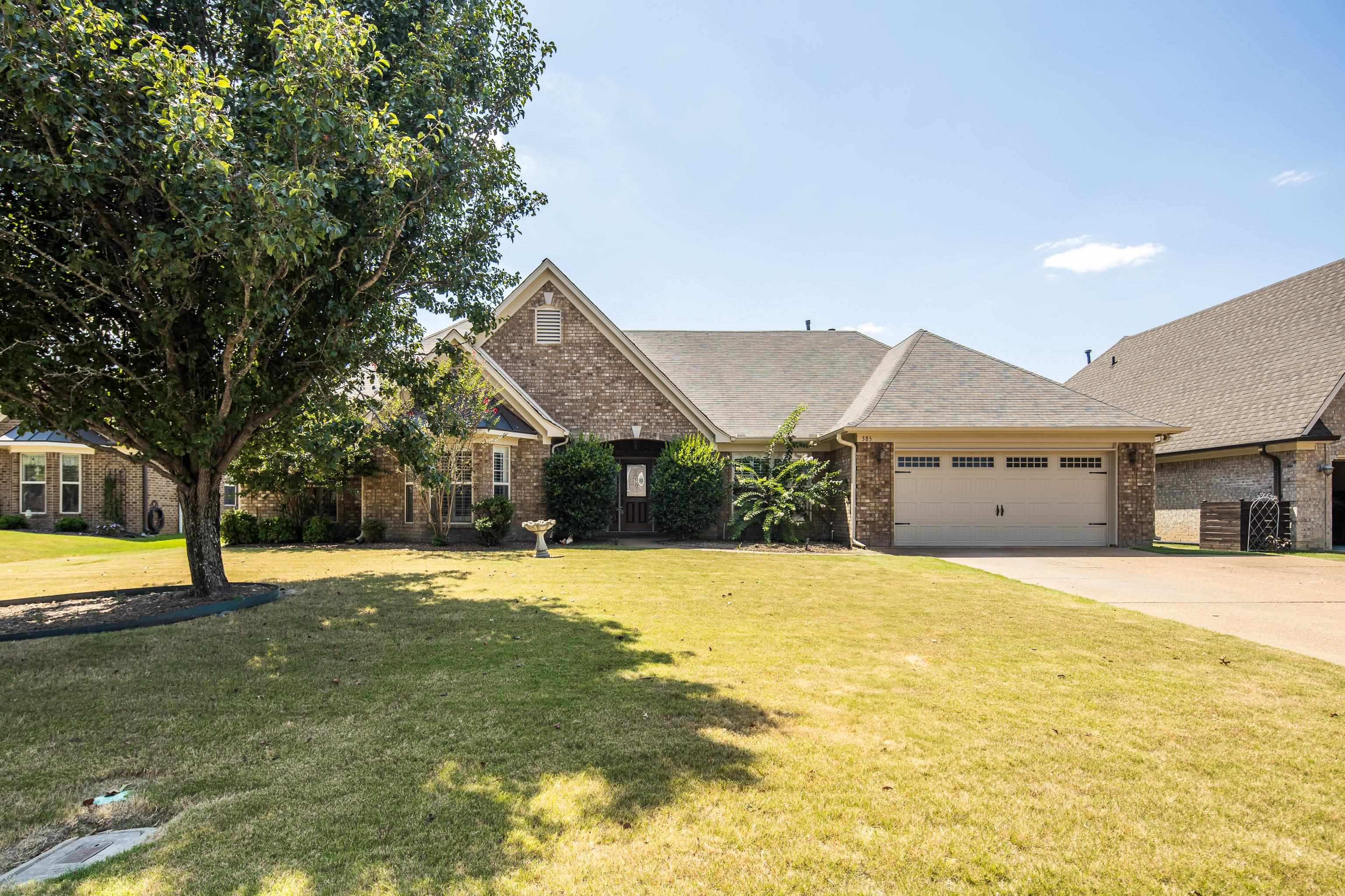 View of front of home featuring a front yard and a garage