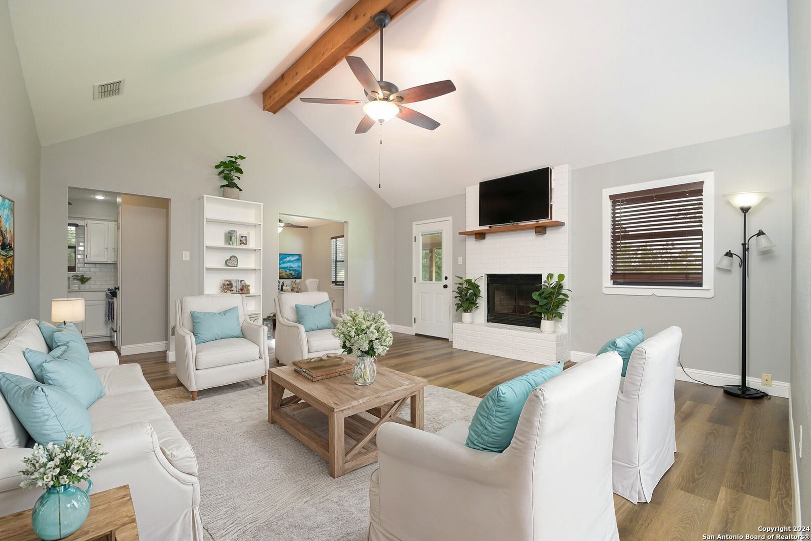 a living room with furniture a flat screen tv and a fireplace