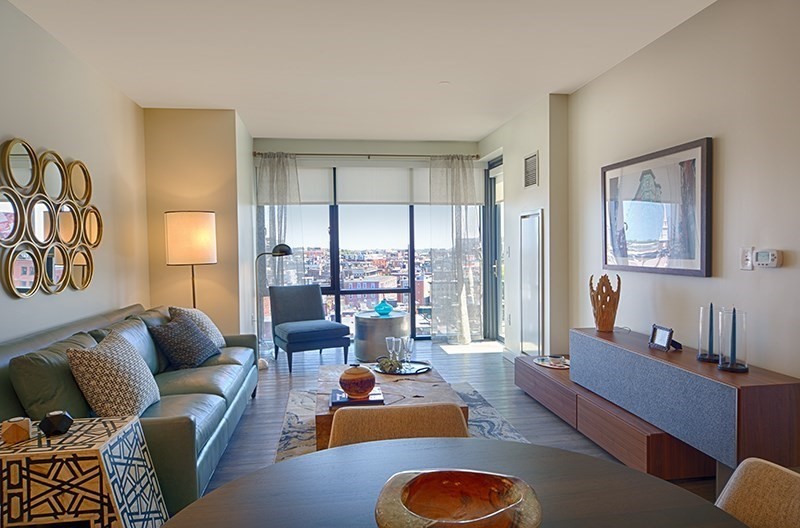 a living room with furniture floor to ceiling window and couch