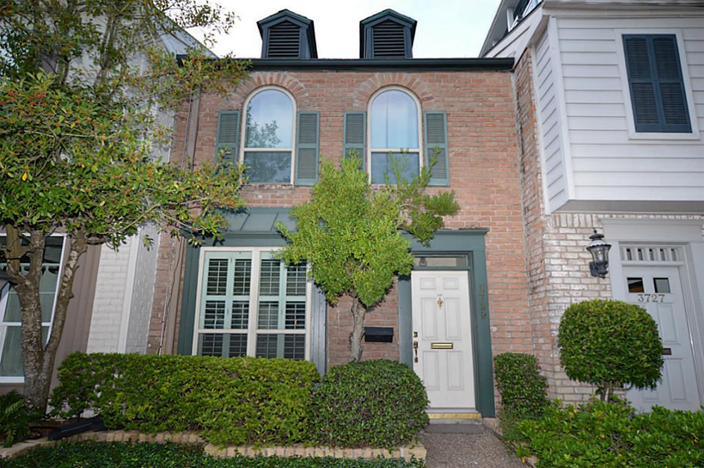 front view of a brick house with a small yard