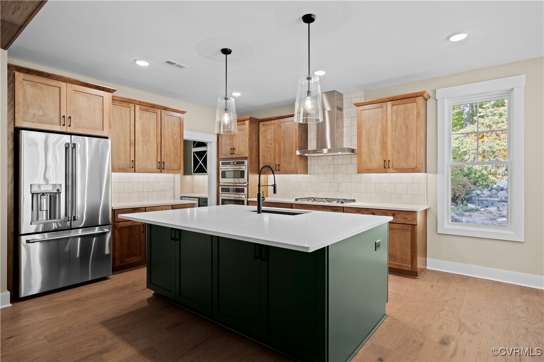 a kitchen with kitchen island a sink stainless steel appliances and cabinets