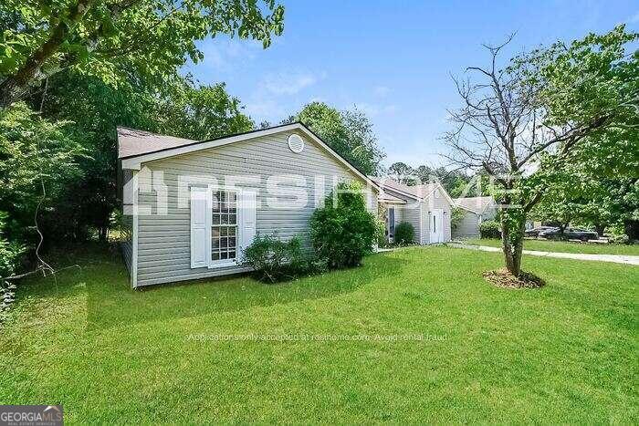 a view of a house with a yard and tree s