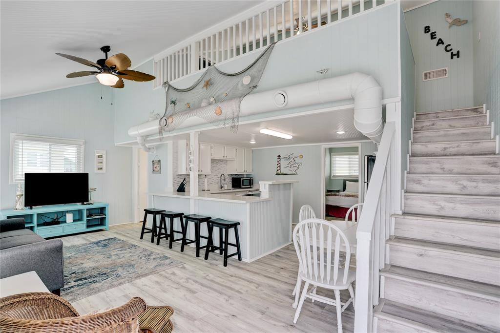 INVITING LIVING AREA WITH VAULTED CEILINGS, GORGEOUS FLOORING AND HUGE WINDOWS THAT ALLOW IN TONS OF NATURAL SUNLIGHT.