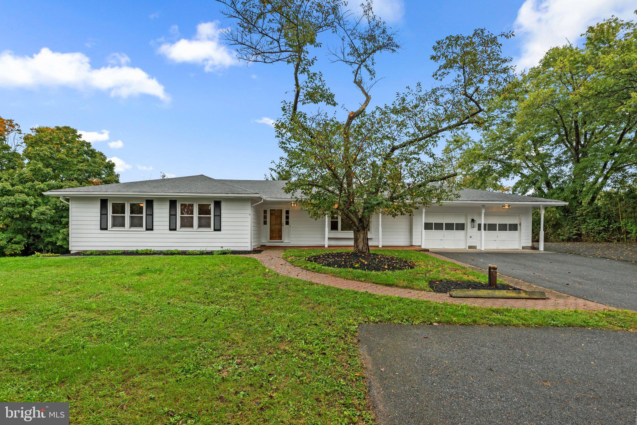 a front view of a house with a yard and trees