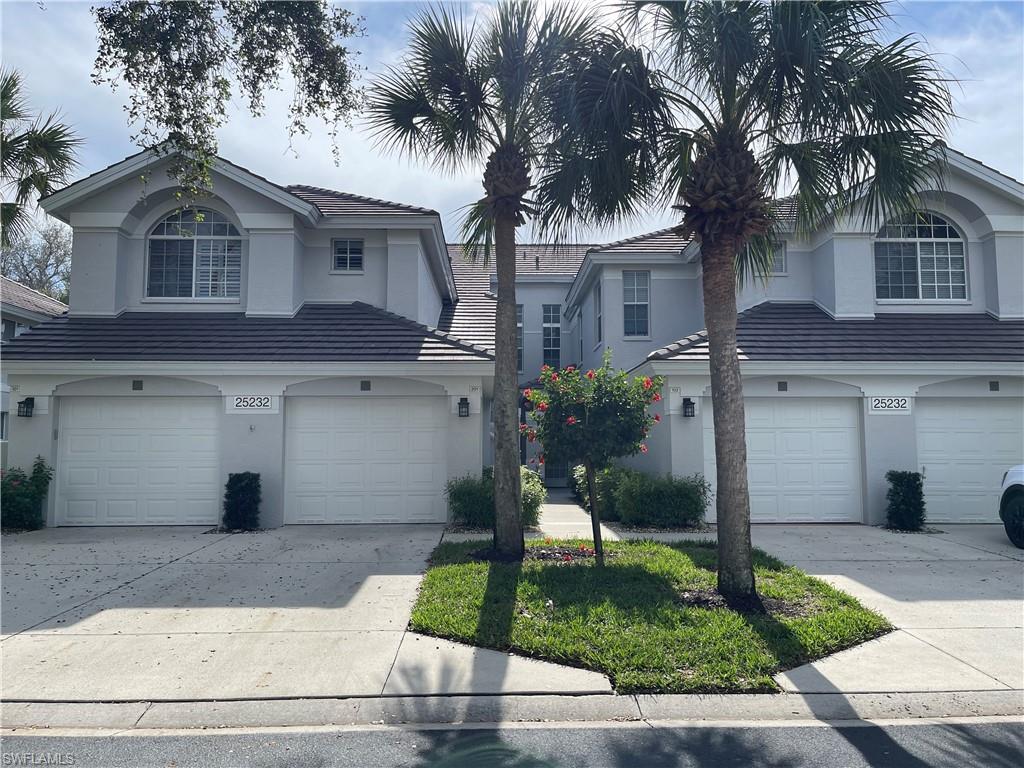 a front view of a house with a yard and palm trees