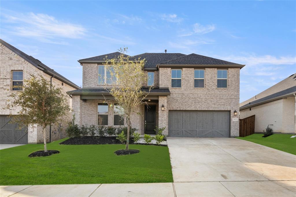 a front view of a house with a yard and garage