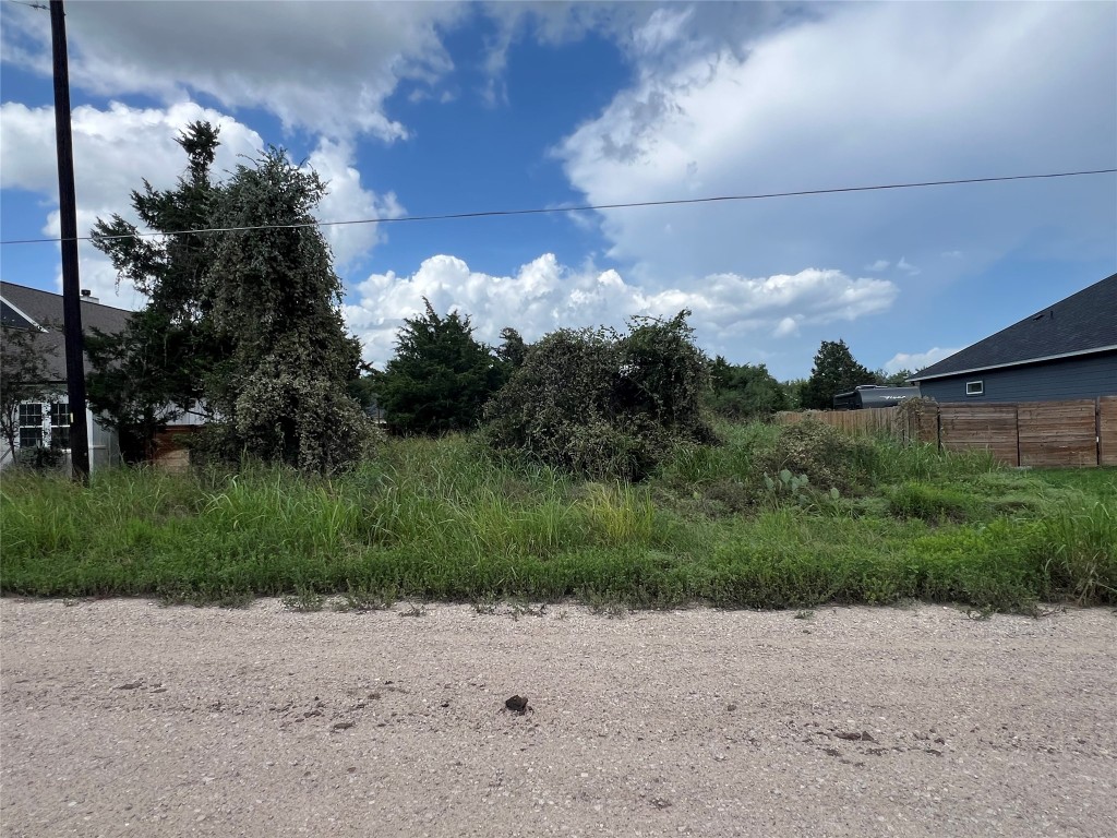 a view of a dirt road with a building in the background