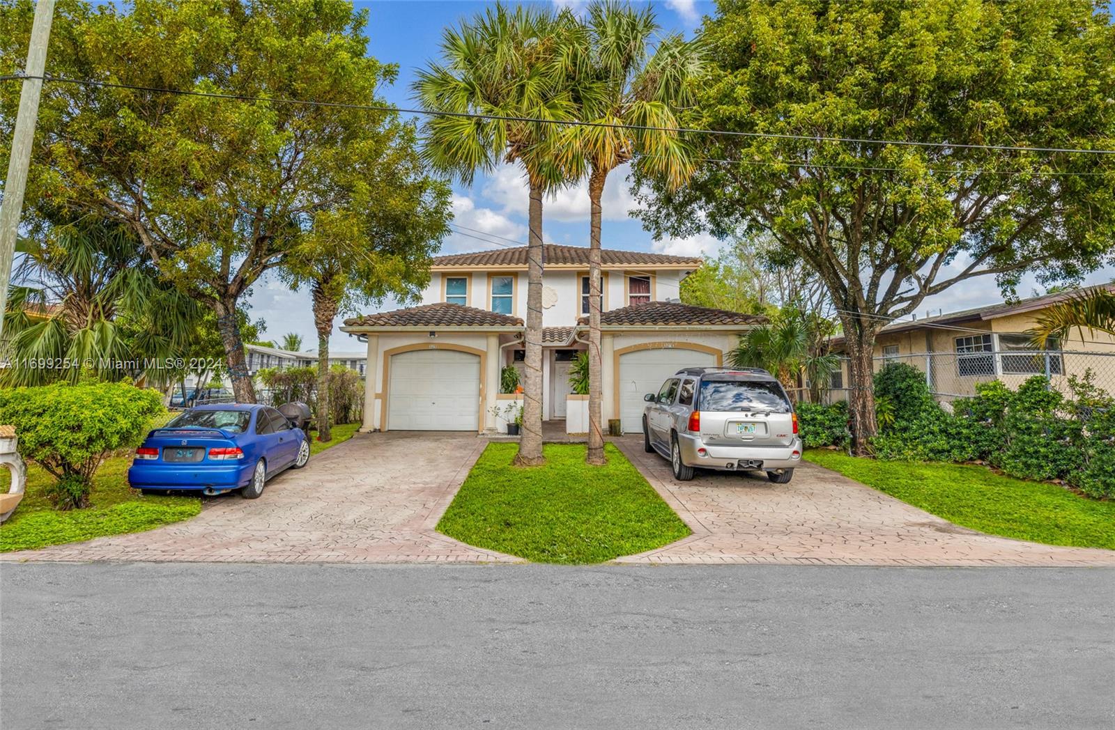 a front view of a house with a garden and trees