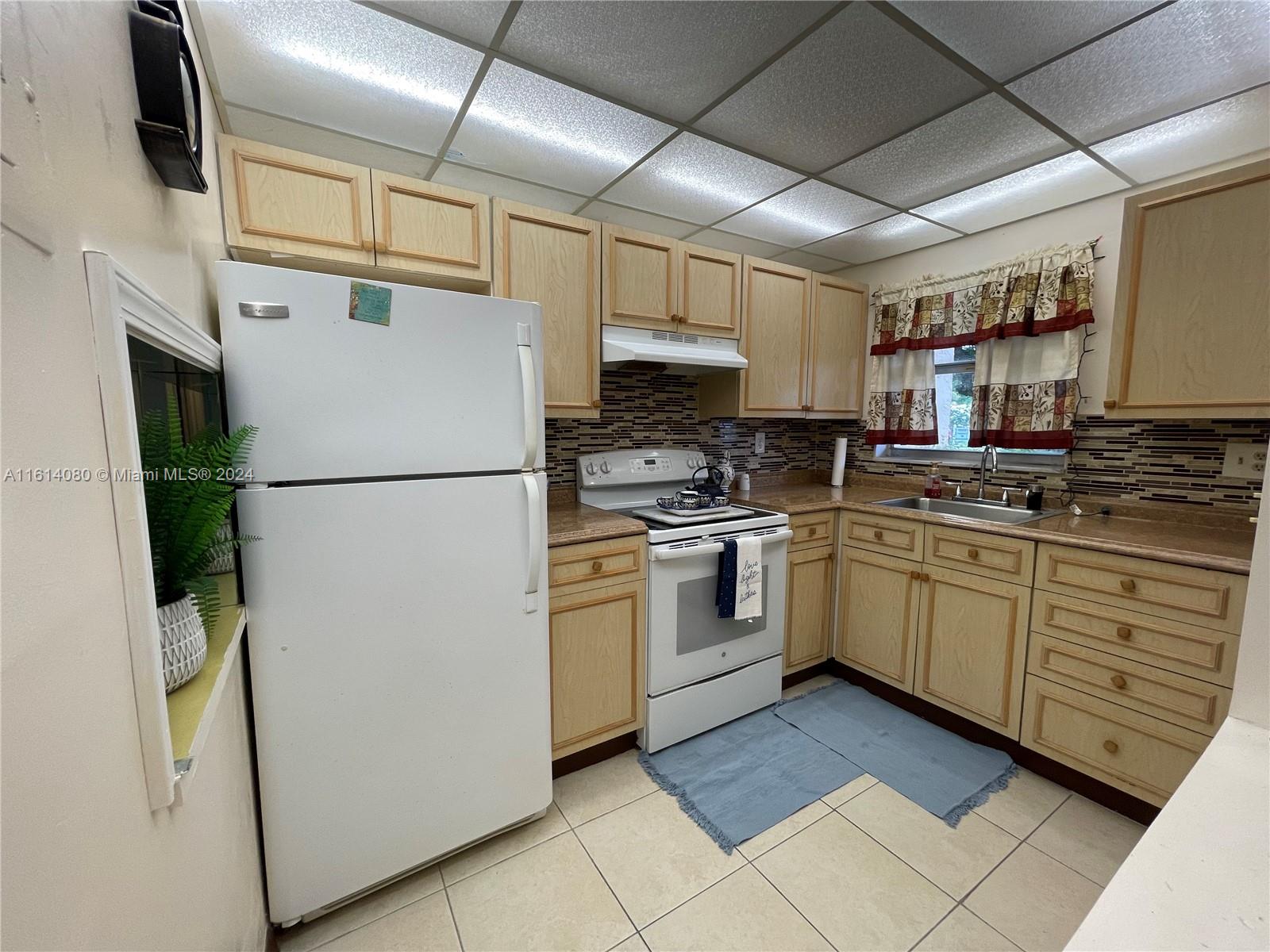 a kitchen with white cabinets stainless steel appliances and a refrigerator