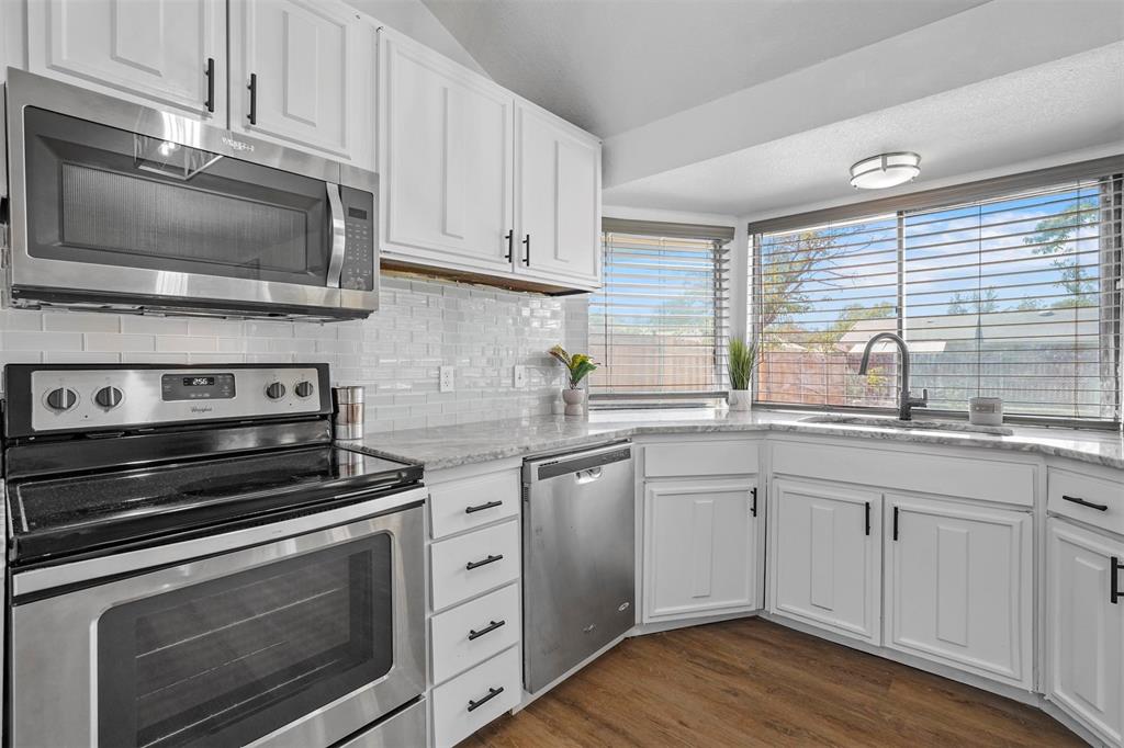 a kitchen with granite countertop a stove microwave and sink