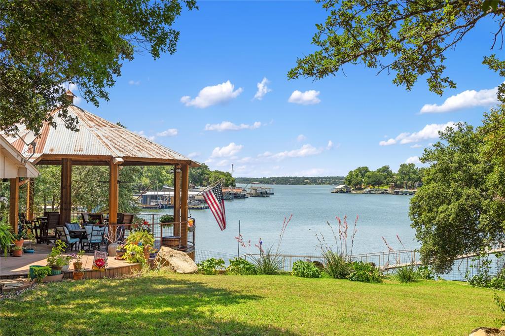 a view of a lake with a big yard and potted plants