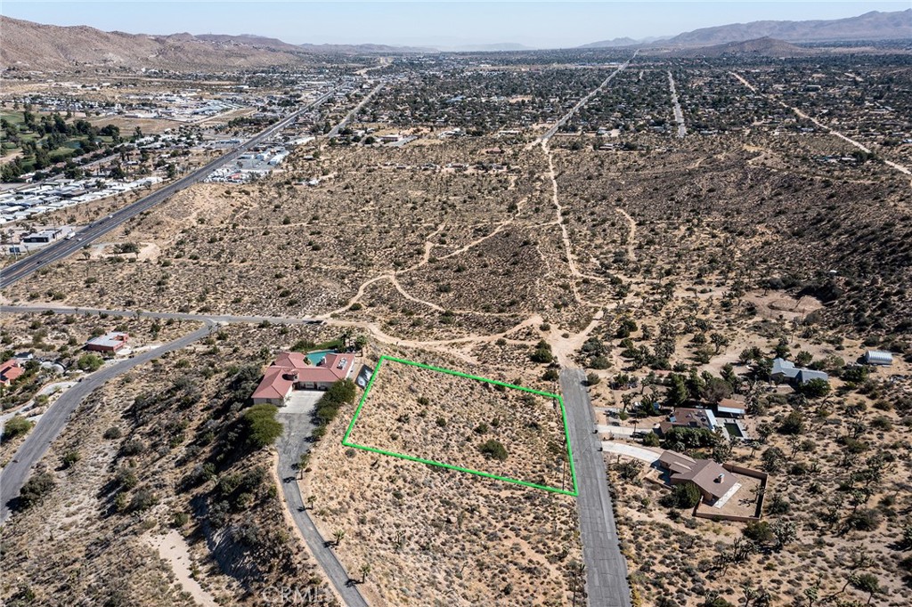 an aerial view of house with yard and mountain view in back