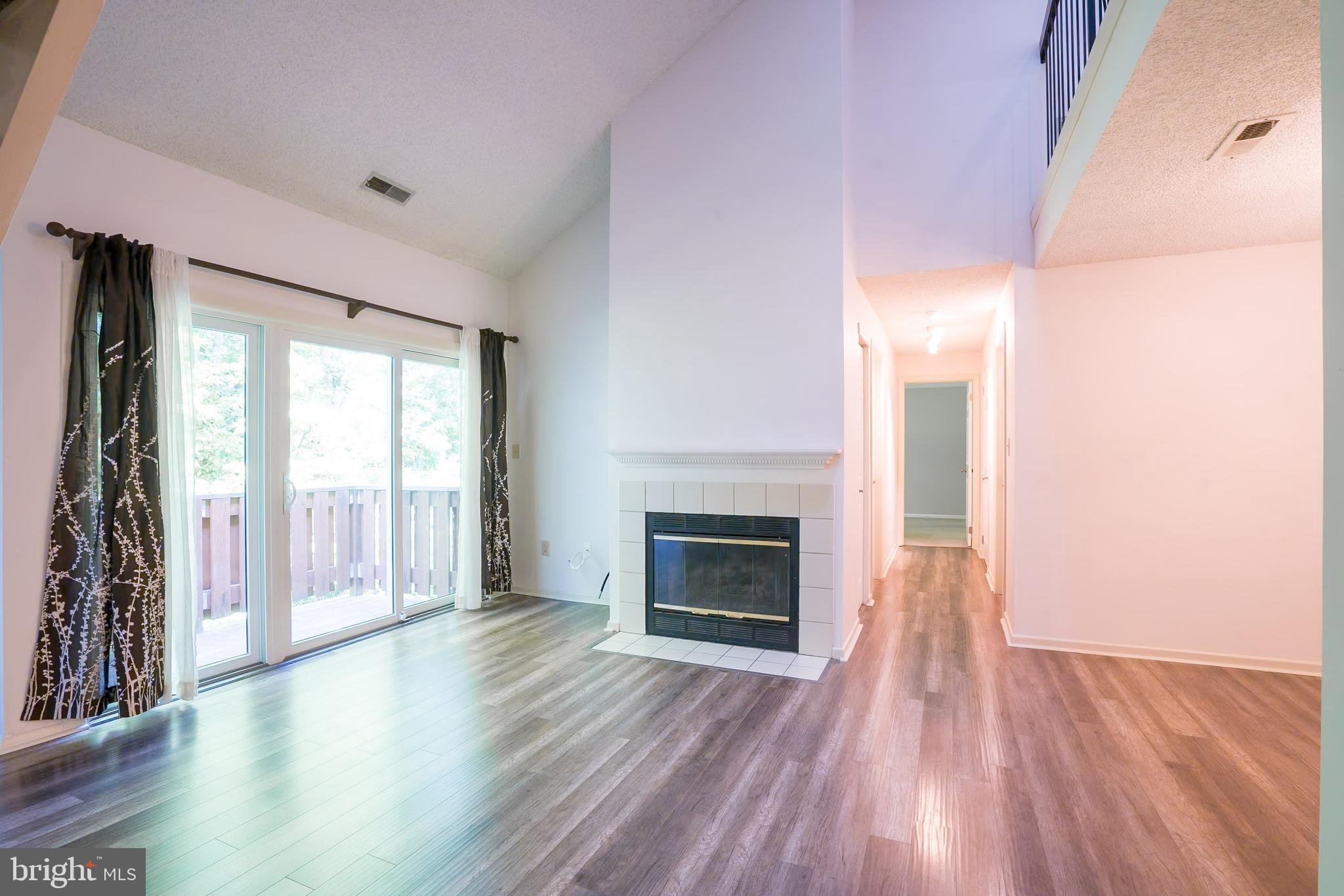 wooden floor fireplace and natural light in room
