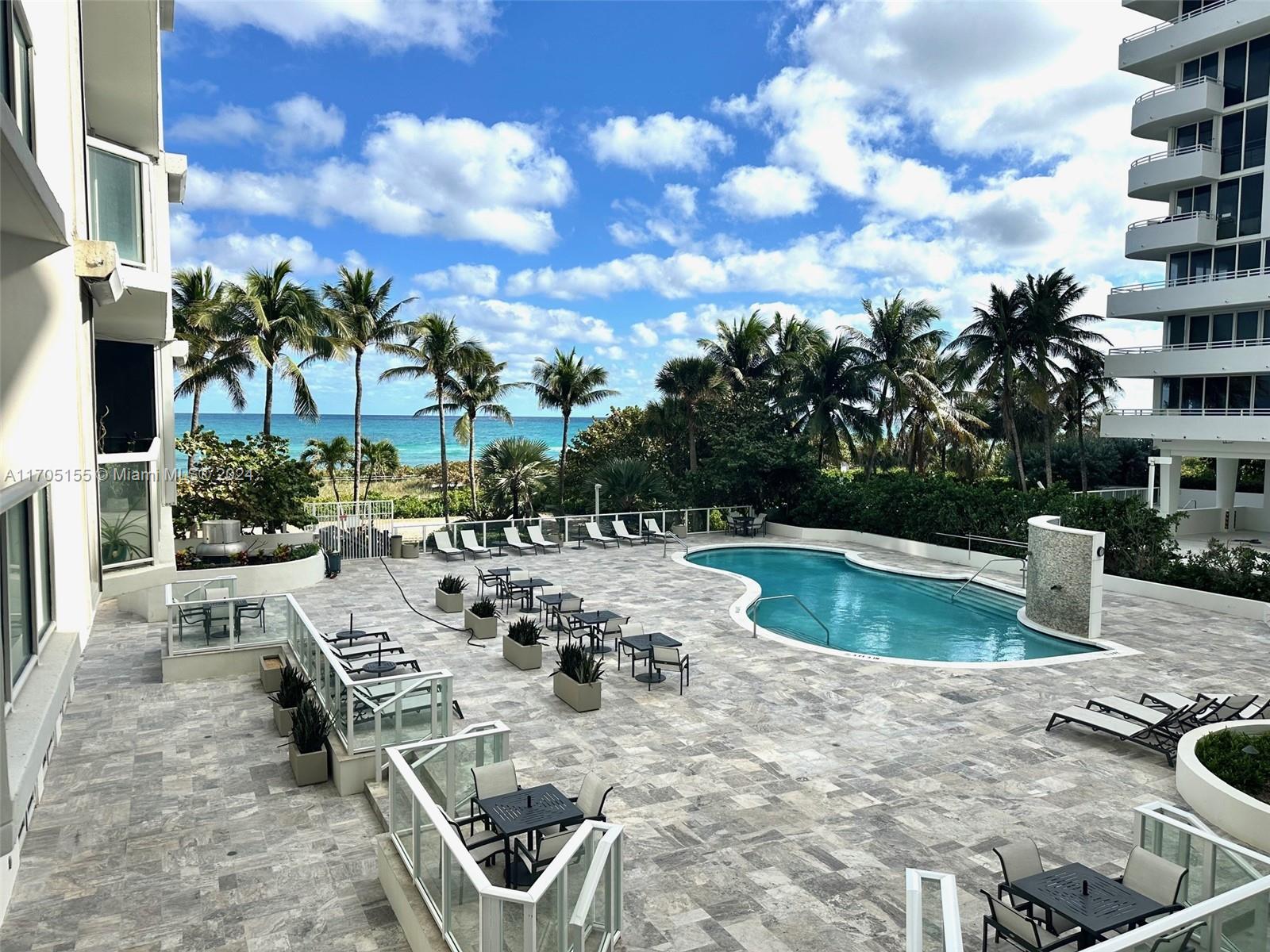 a view of a swimming pool with outdoor seating and plants