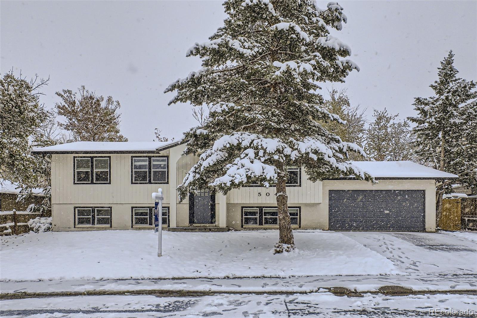 a view of a house with a yard and garage