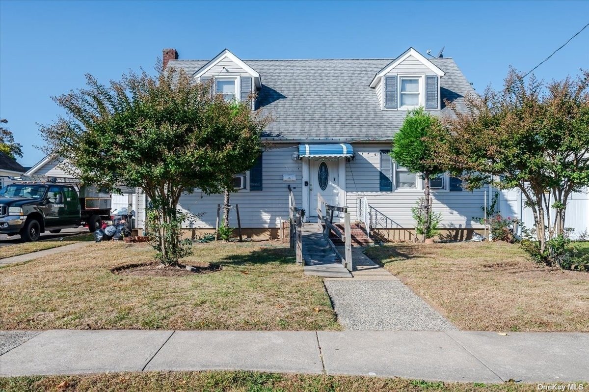 a front view of a house with garden and parking