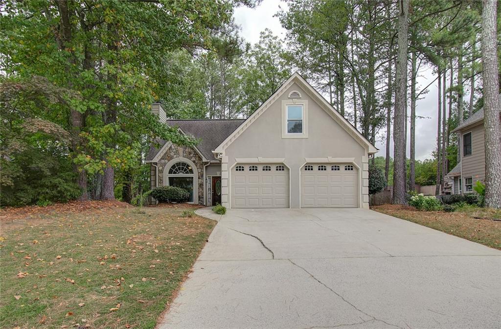 a view of a house with a yard and large tree