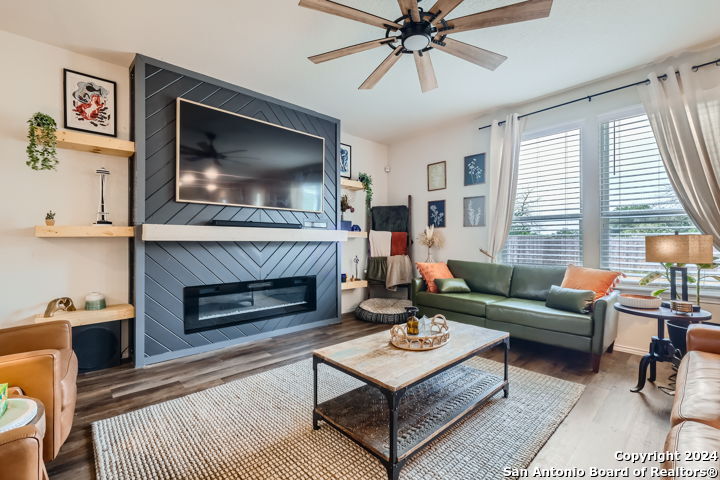 a living room with furniture a flat screen tv and a fireplace