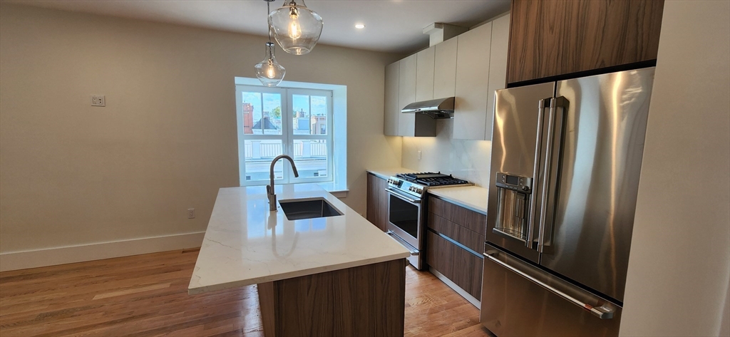 a kitchen with kitchen island a counter top space cabinets and stainless steel appliances