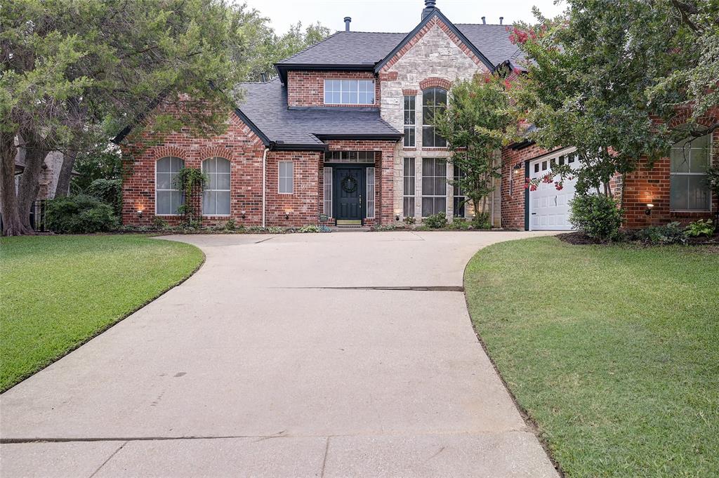 a front view of a house with a garden and trees