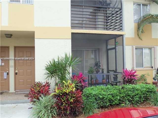 a view of a house with potted plants