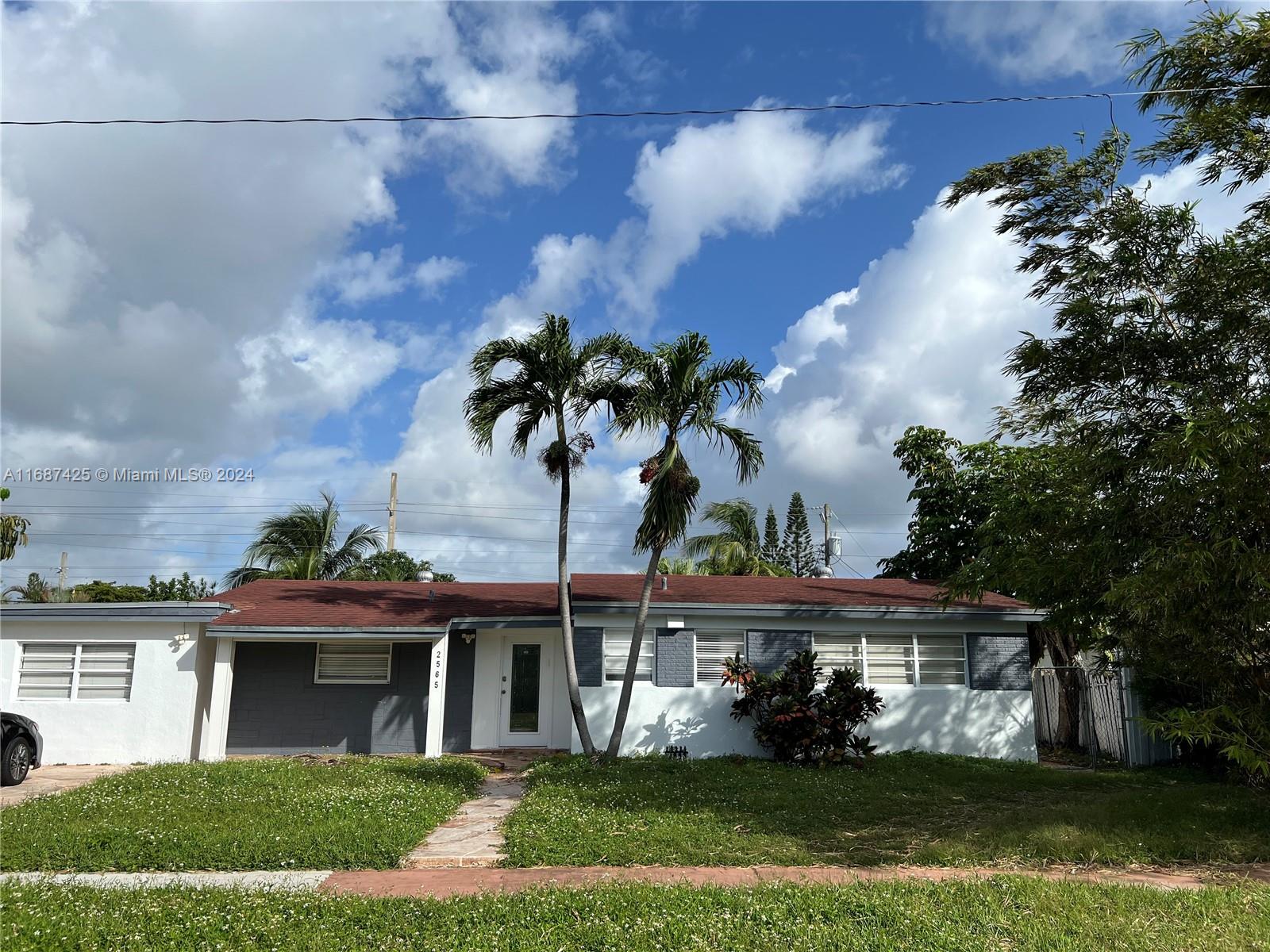 a front view of a house with a garden and plants