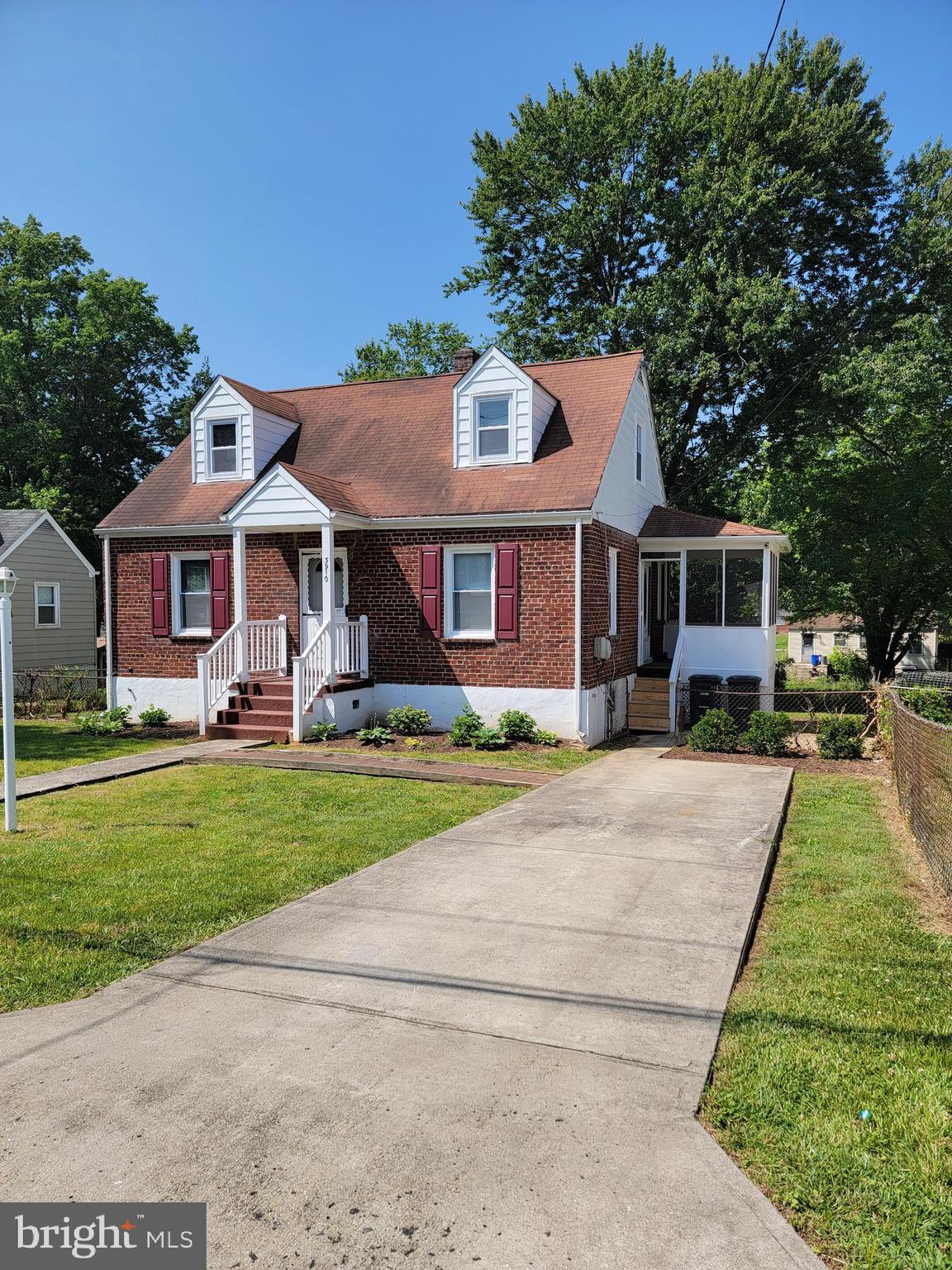 a front view of a house with a yard and trees